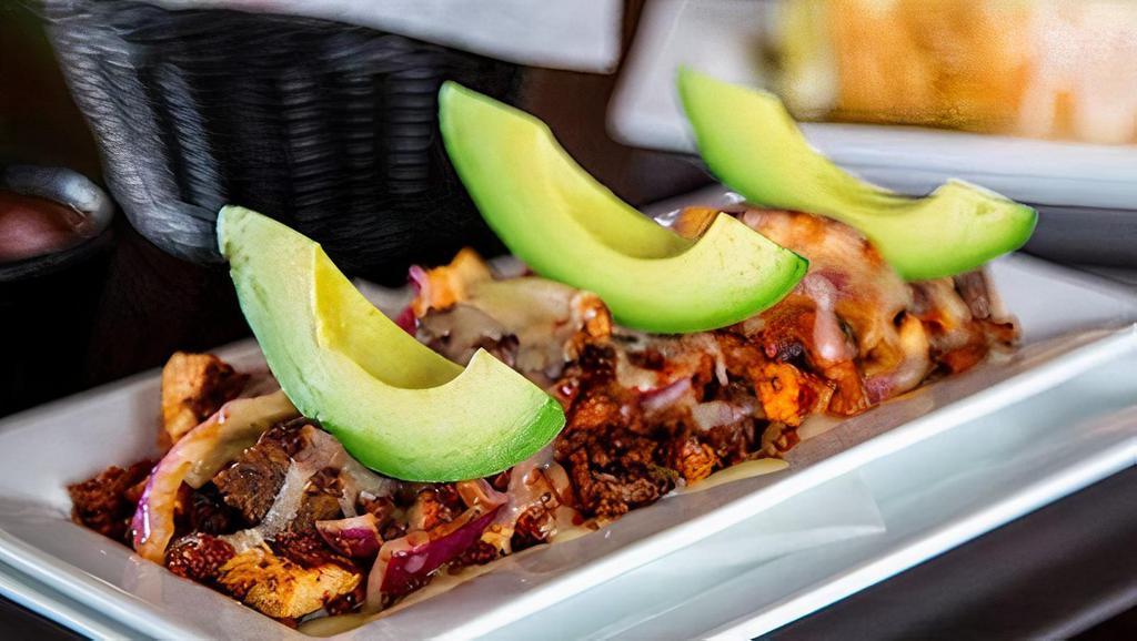 Alambre · Grilled chicken, grilled steak, Mexican sausage and onions all topped with melted Monterrey cheese. Served with spicy sauce and avocado slices. Served with three tortillas.