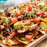 Nachos Supremos · Corn tortilla chips with beef or chicken, beans, lettuce, tomatoes, sour cream, and guacamole.