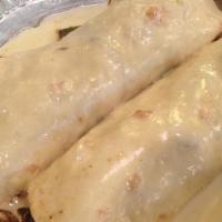 Burritos Rancheros · Two shredded beef burritos topped with cheese, lettuce, tomato, and sour cream served with r...