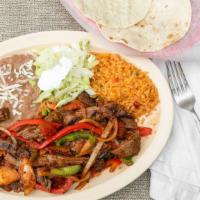Steak Fajitas · Fajitas are grilled with bell peppers and onion. Garnished with Lettuce and Sour Cream. Come...