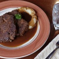 Irish Meatloaf · A thick hearty slice of our special blend meatloaf grilled and served with champs and rich g...