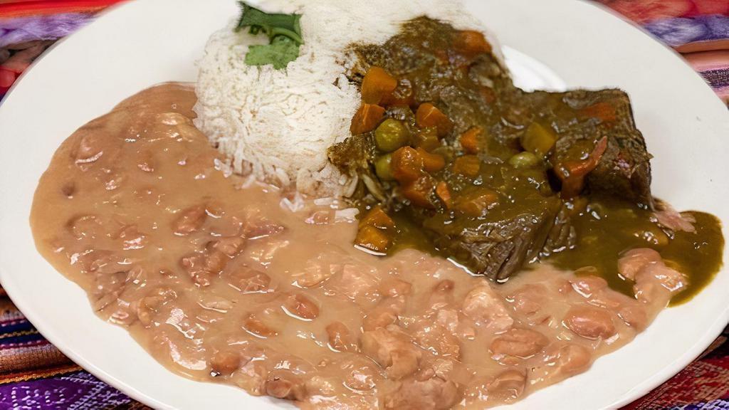 Frejoles Con Seco · Beef cooked in cilantro sauce with side beans, and rice