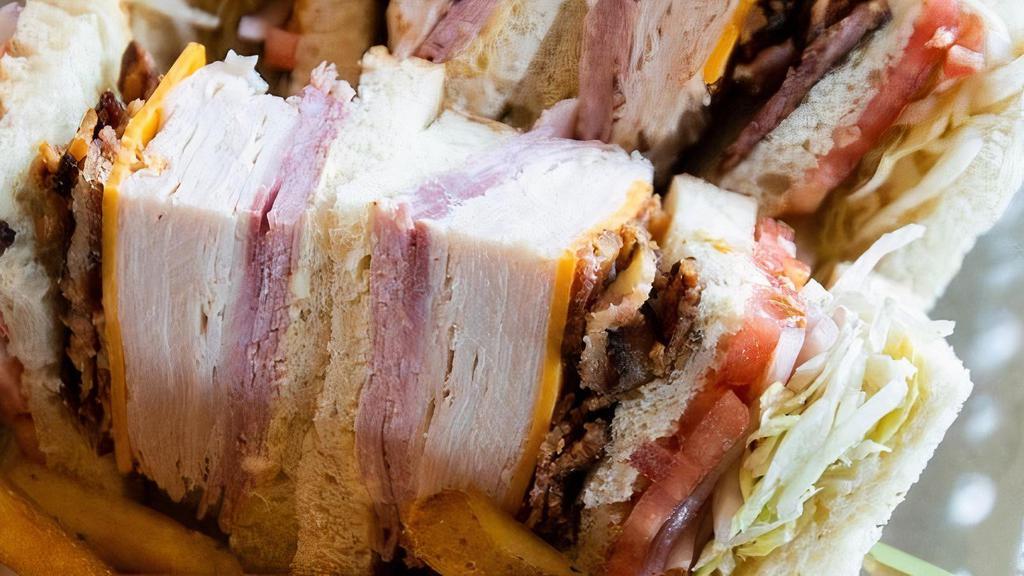 Piled High Club · Turkey, ham, bacon, cheddar, swiss, lettuce, tomato, onion, garlic aioli, and sourdough.