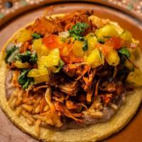 Jackfruit Al Pastor Taco · Marinated jackfruit cooked with sliced onions topped with a pineapple pico de gallo