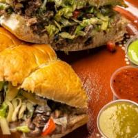 Birria Torta · Birria torta comes with beans, onions, cilantro, melted cheese, sour cream and guac sauce.