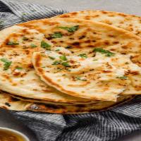 Garlic Naan · Naan is a leavened flatbread made from white flour and herbs. It is topped with melted butte...