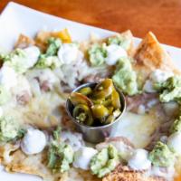 Nachos · Home-made tortilla chips individually layered with re-fried beans, melted cheese, guacamole,...
