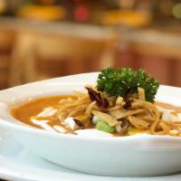 Sopa De Tortilla · A bowl of our traditional chipotle and tomato based tortilla soup topped with avocado, sour ...