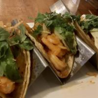 Tacos De Camaron · Three shrimp tacos sauteed in a chipotle garlic butter sauce topped with avocado and micro g...