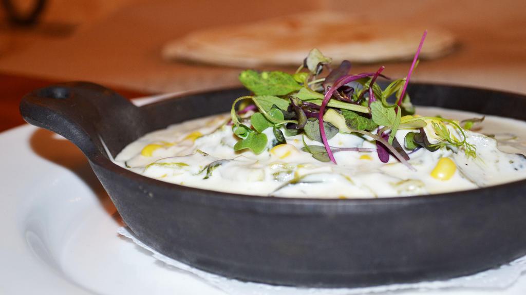 Cazuela De Rajas Poblanas · Creamy casserole of roasted poblano peppers, sliced onions, corn, garlic, and queso cotija. Served with cilantro lime white rice and warm tortillas.