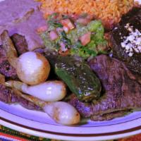 Carne Tampiqueña · Grilled steak with a mole enchilada, guacamole and grilled Cambray onions. Items marked with...