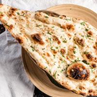 B-2. Garlic Naan · Light and fluffy authentic Indian bread baked with garlic and cilantro.