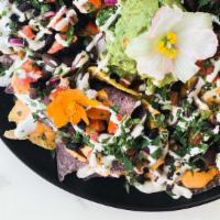 Nachos · blue and yellow corn chips topped with homemade pinto and black beans, queso, sour dream, pi...