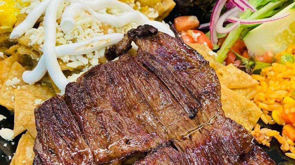 Carne Asada Al Carbón / Charbroiled Steak · Bistec a la brasa, servido con arroz, frijoles y patatas. / Charbroiled steak, served with rice, beans and potatoes.