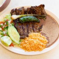 Carne Asada · Grilled steak served with rice, beans and pico de gallo, with fresh tortillas.