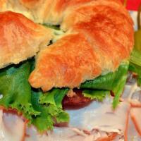 Club Croissant Smoked Turkey · Slices of turkey breast, bacon, lettuce, tomato and mayo on a French croissant.