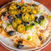 Super Nachos · Our house-made corn tortillas topped with ground beef, muenster cheese, lettuce, tomatoes, o...