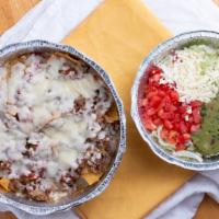 Nachos Supreme · Nachos topped with ground beef, chopped chicken, beans all covered with lettuce, sour cream,...