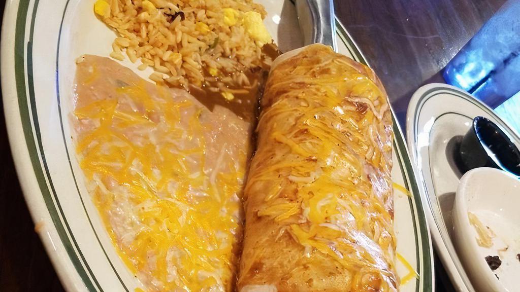 El Grande · Filled with chili con queso, lettuce, tomato, topped with enchilada sauce, served with Mexican rice & refried beans
