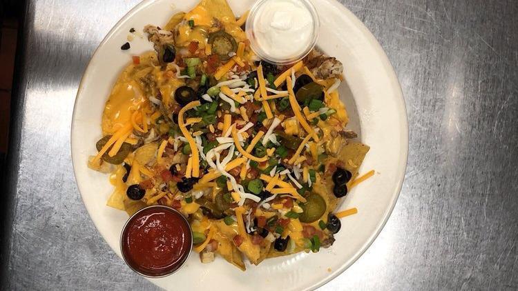 Chicken Nacho Supreme · Fresh corn tortilla chips with a sliced grilled chicken breast drizzled with queso, pico, jalapenos black olives, chives, tomatoes, salsa and sour cream.