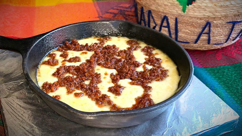 Queso Fundido · A delicious blend of baked Chihuahua cheese and chorizo (Mexican sausage). Served with warm tortillas.