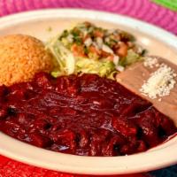 Guisado De Puerco En Chile Guajillo  · Pork tenderloins simmered in a chile guajillo sauce. Served with Spanish rice and refried be...
