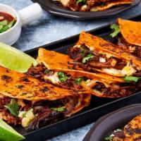 Quesa Birria · Three tacos filled with birria (slowed cooked shredded beef)and melted cheese, topped with c...