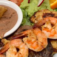 Mar Y Tierra · Marinated grilled sirloin steak topped with grilled shrimp. Served with side of salad, mashe...