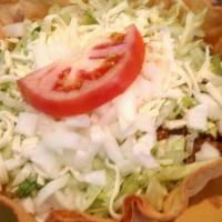 Taco Salad · A crispy flour tortilla filled with ground beef or chicken, beans, lettuce, tomatoes, grated...