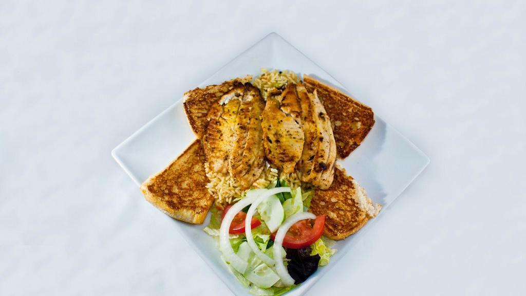 Tilapia Dish · Served on a bed of rice with a small salad, coleslaw, and garlic bread.