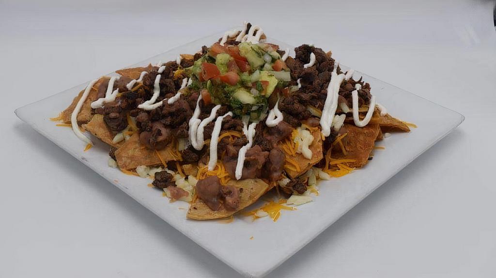Mexican Nachos · Your choice of  grilled meat, cheese, sour cream, beans, steak,,chicken or pastor & pico de gallo