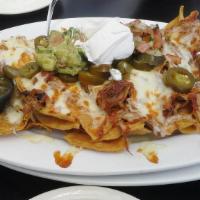 Nachos Grande · A heaping pile of chips with chihuahua cheese, refried beans, guacamole, jalapeno slices, so...