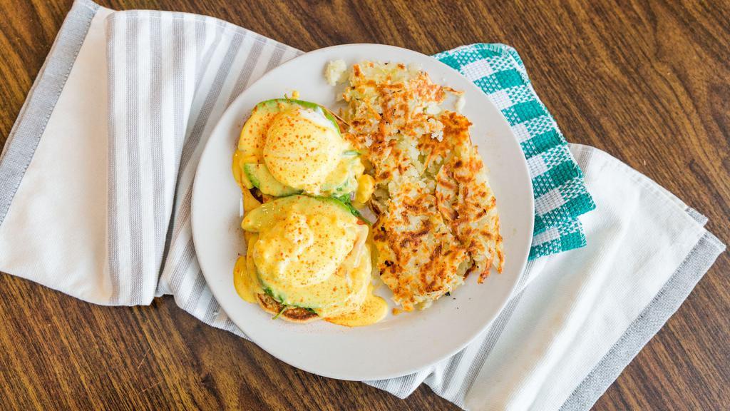 Avocado Benedict · Poached eggs, toasted English muffin, avocado, tomatoes, spinach, hollandaise sauce and hashbrown.