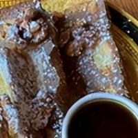 French Toast · Two pieces of Texas toast in an orange cinnamon batter with candied nuts, maple syrup, and w...