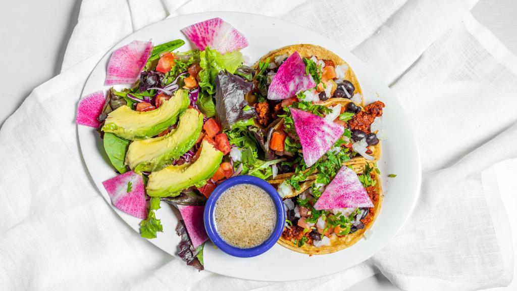 Vegan Taco Plate · 3 corn tortillas filled with your choice of vegan option, black beans, cilantro, radish, onion, and tomato, paired with a mixed green salad, with avocado, red cabbage, tomato, radish and our lime cumin vinaigrette.