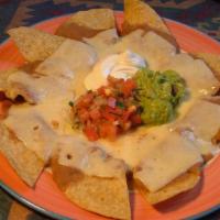 Nachos · Corn tortilla chips topped with refried beans and Mexican cheese. Served with fresh guacamol...
