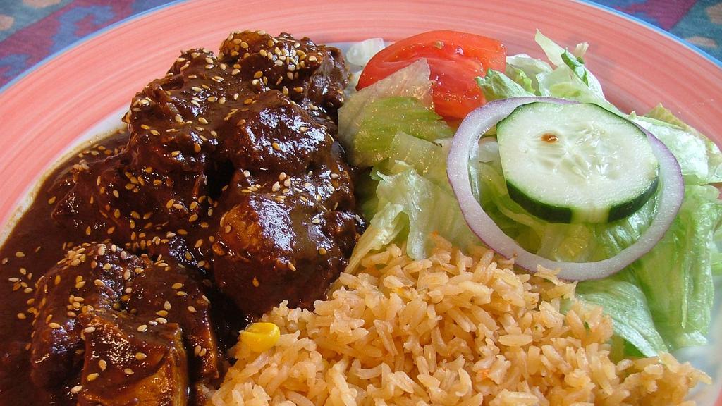 Pollo Con Mole Poblano · Tender pieces of chicken simmered in our delicious and unique mole sauce. Served with refried beans and Spanish rice.