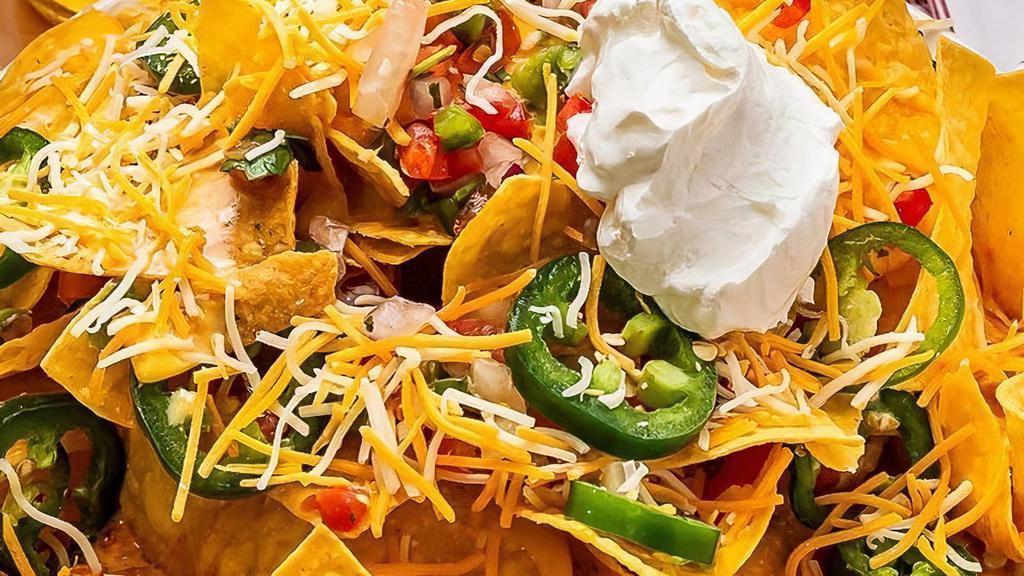 Nachos · Choice of beef, chicken or pork atop fresh tortilla chips piled high with spicy cheese sauce, diced tomato, fresh jalapeño, scallions, and sour cream