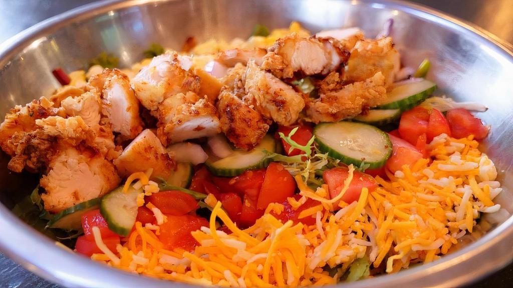 Fried Chicken Salad · Spring mix topped with hand breaded chicken tenders, tomatoes, Monterey Jack and cheddar cheeses, bacon, cucumbers, hard boiled egg, red onion. Served with your choice of homemade dressing.