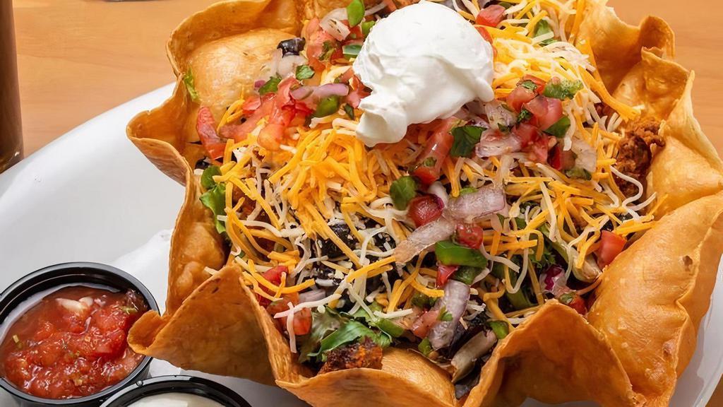 Taco Salad · Deep fried tortilla stuffed with spring mix, seasoned ground beef, monterey jack and cheddar cheeses, black beans, tomato, red onion, salsa and sour cream.