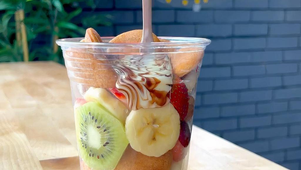 Classic Fruit Cup · Mini pancakes, strawberries, bananas, and kiwis with a side of Nutella, white chocolate and chocolate syrup cup to pour over
