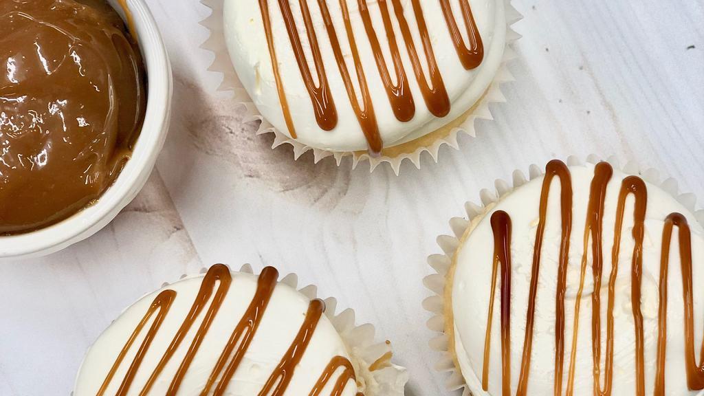 Salted Caramel · Classic vanilla cake filled with a delicious caramel filling, topped with vanilla buttercream, drizzled with a caramel sauce and sea salt.