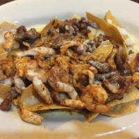 Nachos Mexicanos · This one has it all - beef, chicken and shrimp over tortilla chips, finished with nacho chee...