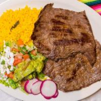 Carne Asada · Two pieces of grilled steak served with rice, beans, guacamole salad and three tortillas.
