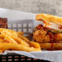 Nashville Hot Chicken Waffle Sandwich · Chicken strips smothered in Nashville hot sauce with honey, maple syrup, and pickles - on a ...