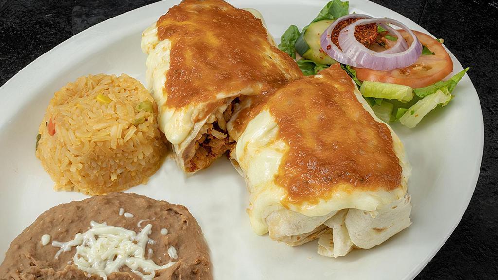 Burrito Suizo · Swiss-style burrito with your choice of meat and topped with melted Swiss cheese and our ranchero salsa. Served with Mexican rice, re fried beans, sour cream, pico de gallo, lettuce, and tomatoes.