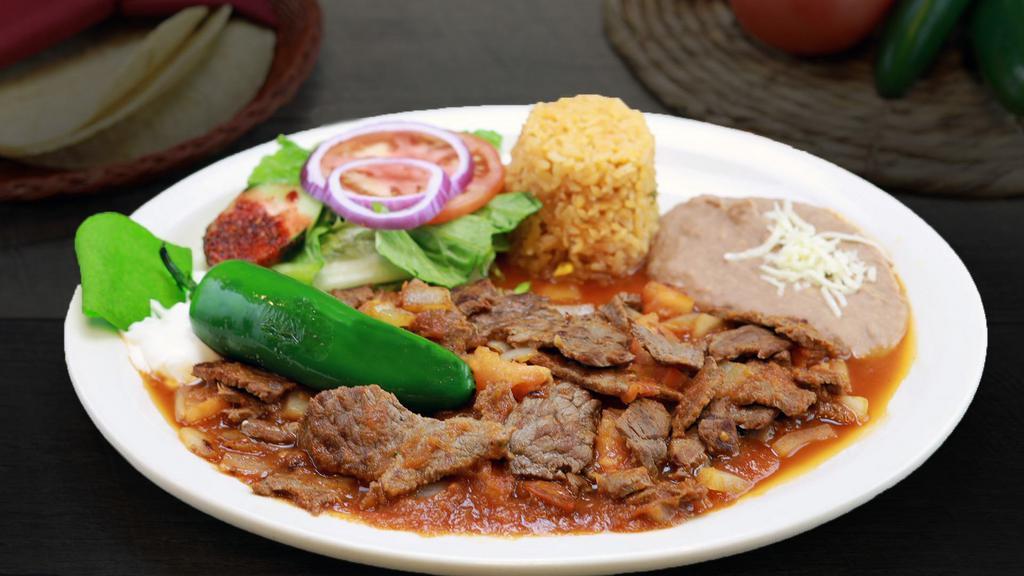 Lomo En Chile De Arbol · Tender pieces of rib eye Steak sauteed with delicious spicy chile de arbol salsa. Served with Mexican rice, re fried beans, sour cream, pico de gallo, lettuce, and tomatoes.