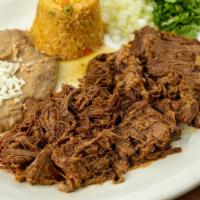 Barbacoa De Res · Mexican style barbecue beef. Served with rice, refried beans, onions, and cilantro.