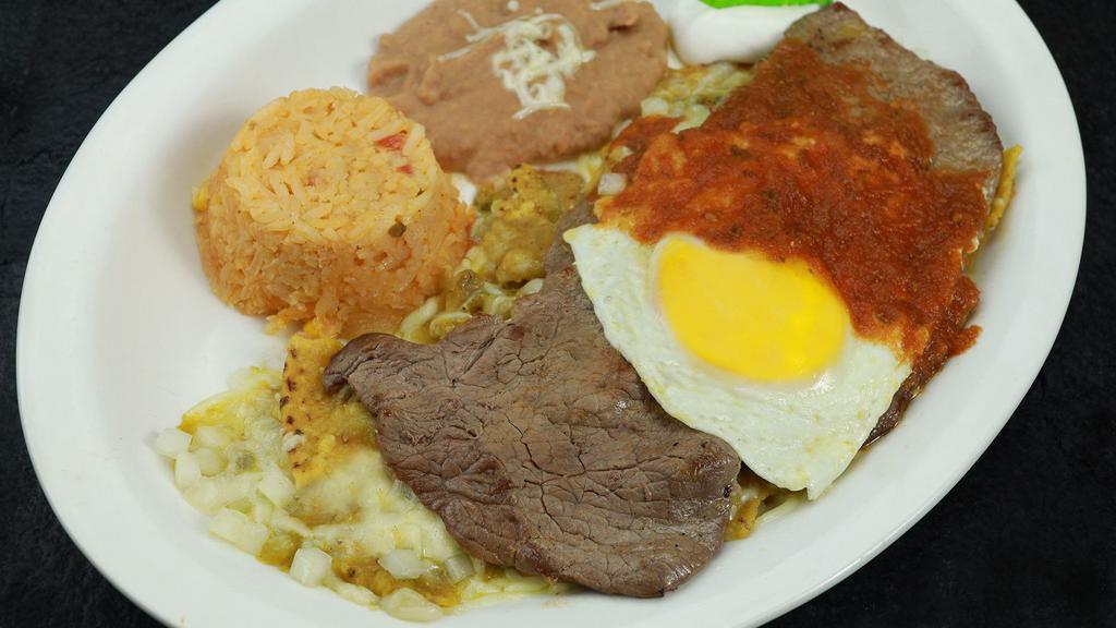 Chilaquiles · Traditional chilaquiles sauteed in green or red salsa accompanied with steak and one sunny side up egg. Served with Mexican rice, and re fried beans.