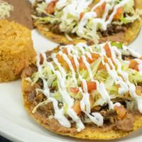  Dos Tostadas Con  Arroz Y Frijoles American Style · Two tostadas with Mexican rice and re fried beans.
